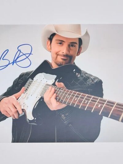 Man in cowboy hat holding electric guitar.