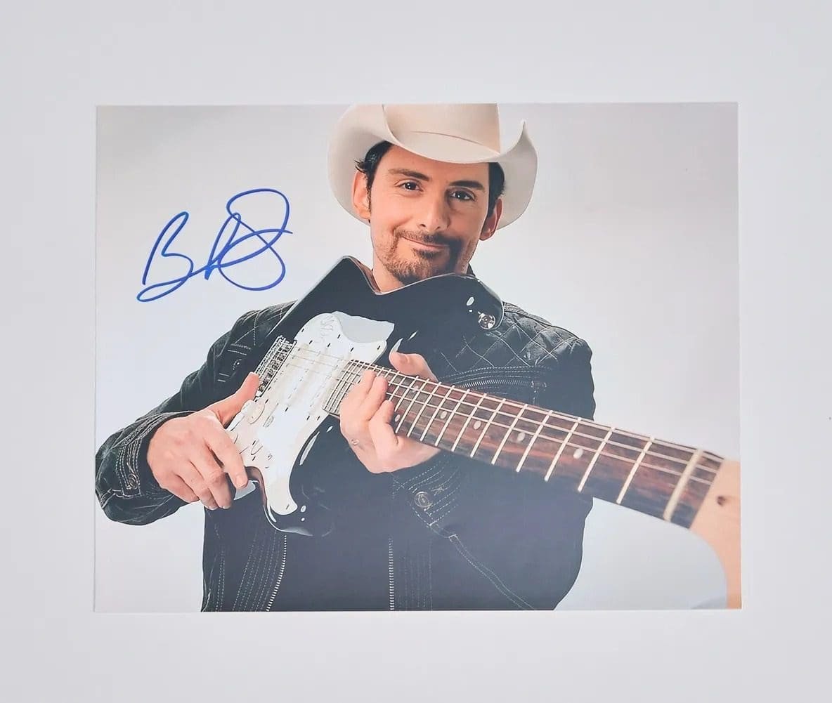 Man in cowboy hat holding electric guitar.