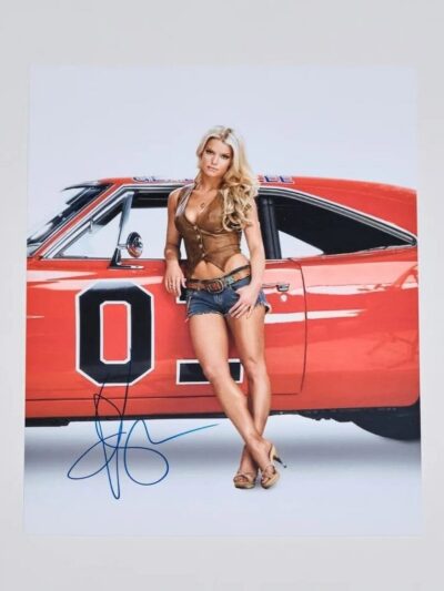 Woman posing by red vintage car.