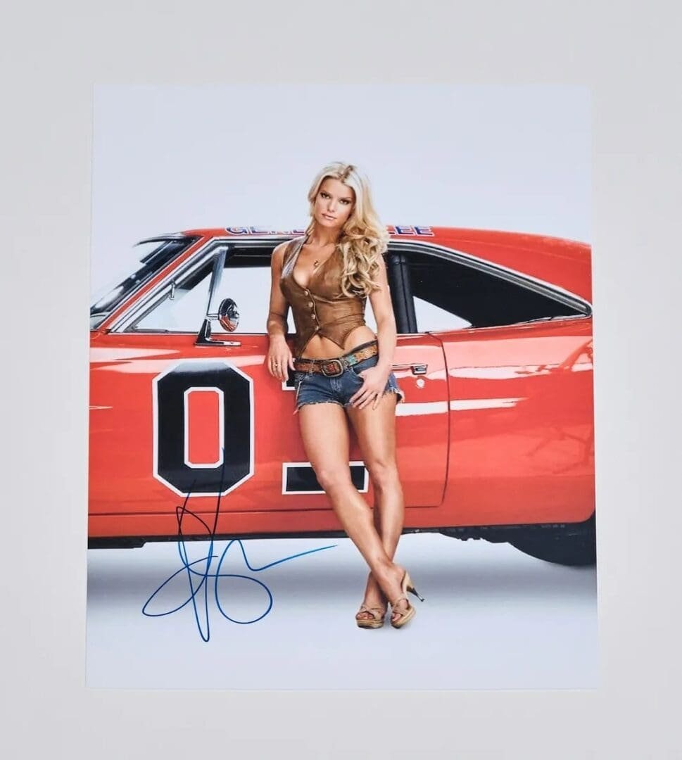 Woman posing by red vintage car.