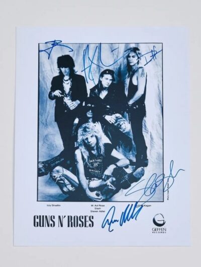 Band members posing with autographs on photo.
