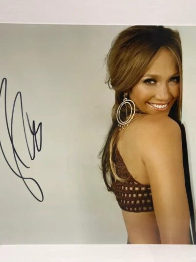 Smiling woman with signature on photograph.