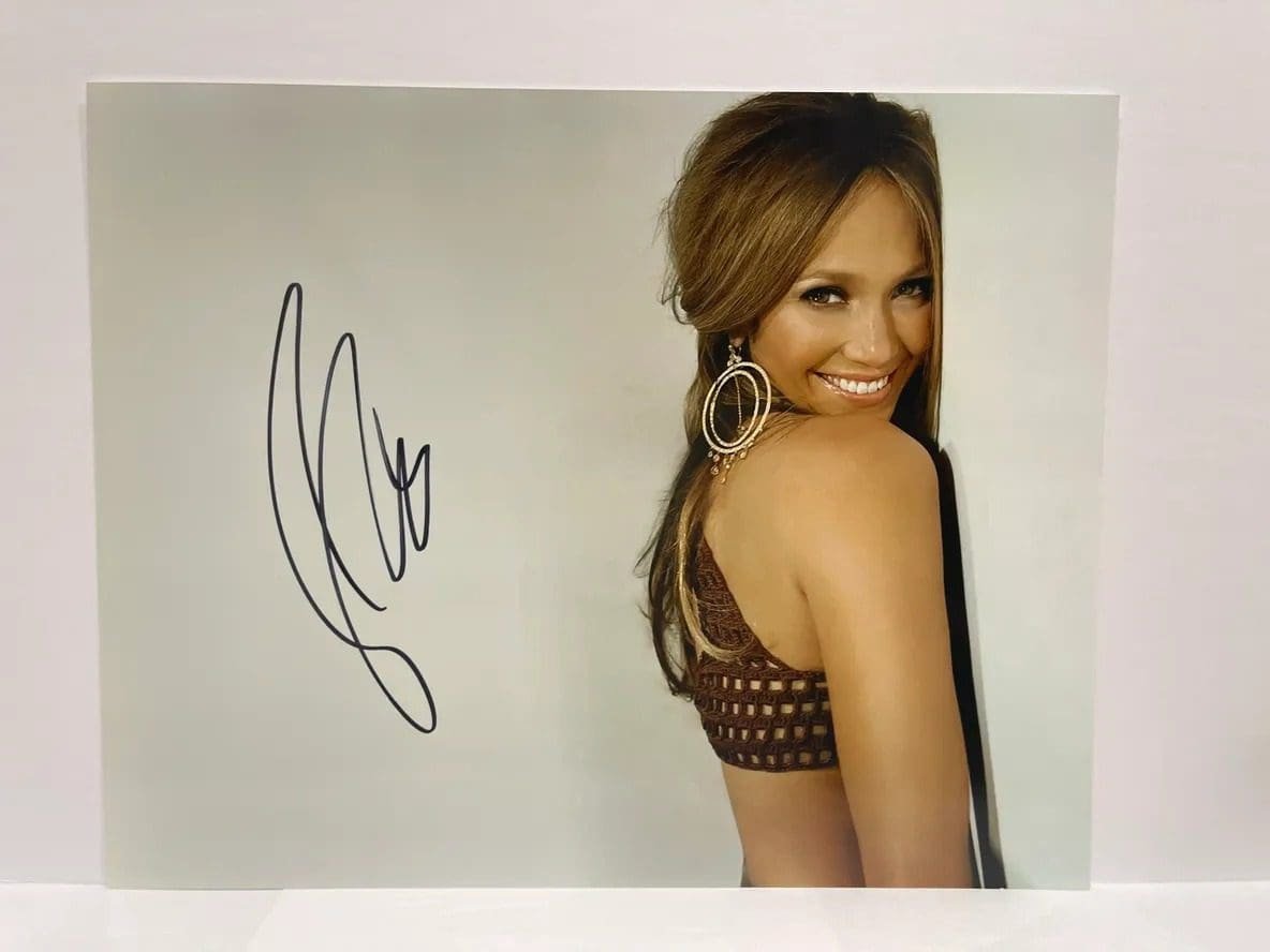 Smiling woman with signature on photograph.