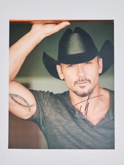 Man in cowboy hat with arm tattoo.