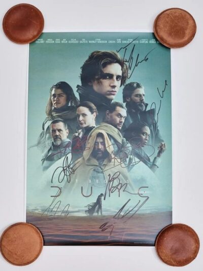 Movie poster with signatures and round objects.