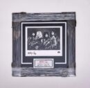 Framed autographed band photo with signatures.