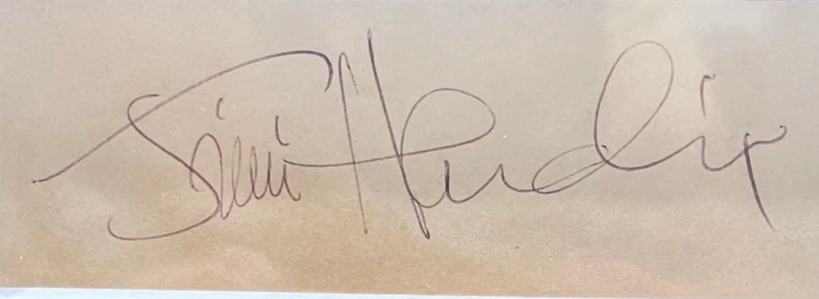 Cursive signature on beige background.