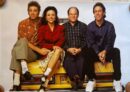Four people sitting on a yellow taxi.